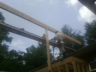 Carpenter setting a ridge beam over a new addition frame — Ice Dam Removal by Roofing Brothers in Willard