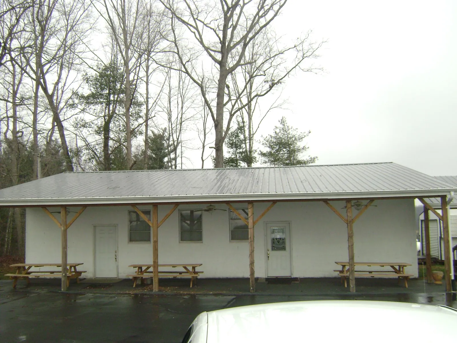 Gray metal roof over a block building with a timber post porch in Willard